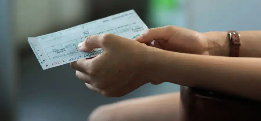 Mãos de mulher a segurar bilhete simbolizando revenda