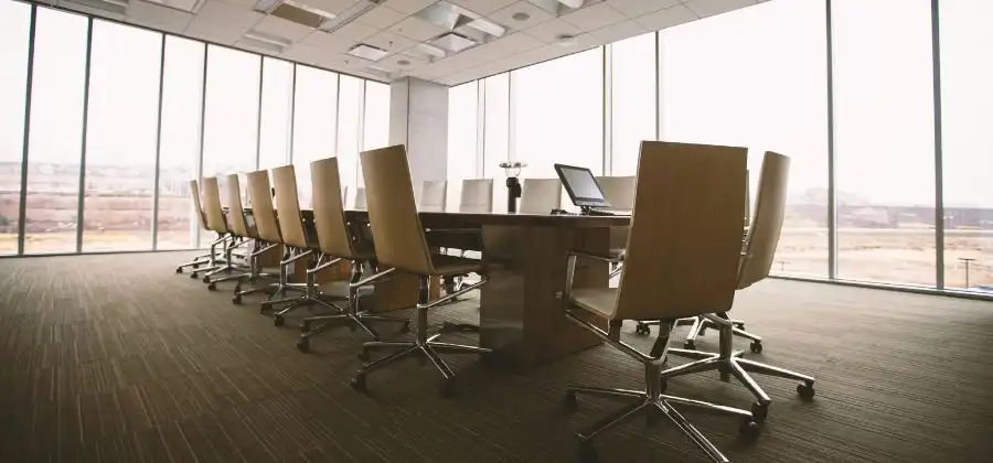 Sala de reuniões com janelas e mesa com cadeiras em volta