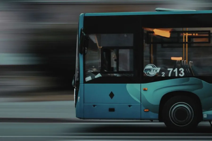 Autocarro azul em movimento a deslocar-se para a esquerda