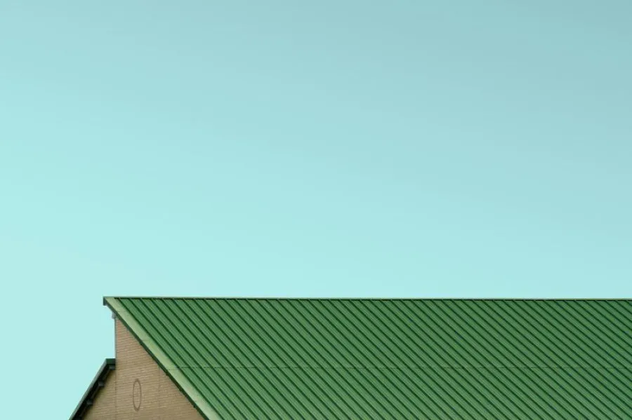 Céu azul e telhado verde de uma casa a aparecer