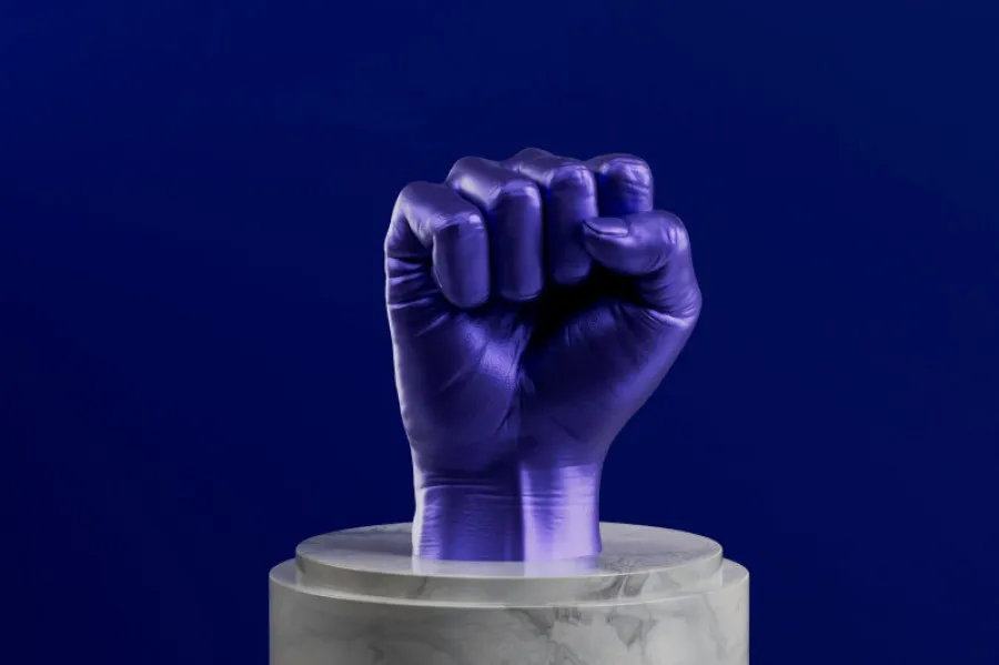 Punho erguido em roxo sobre pedestal de mármore, simbolizando força e reivindicação de direitos laborais ou prémios salariais.