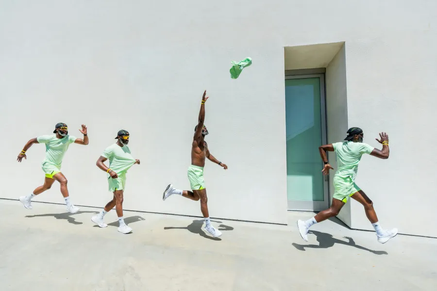 Série de fotografias de um homem vestido de verde a pular no ar enquanto anda pela rua