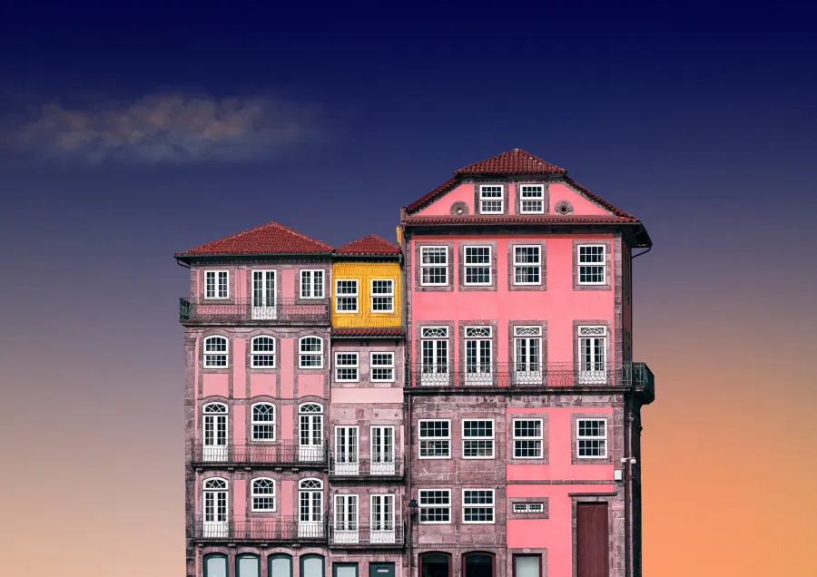 Prédios coloridos antigos típicos de Portugal com céu ao entardecer ao fundo.