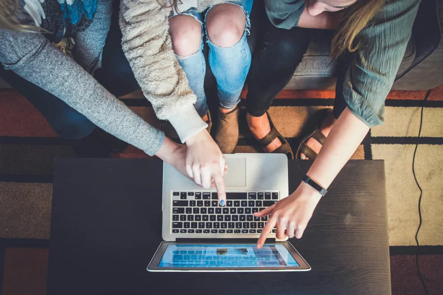 Pessoas na frente do computador a tentar escolher o melhor crédito pessoal