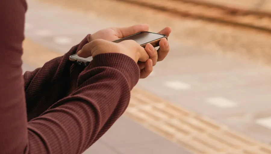 Pessoa a usar smartphone - conceito de gestão de finanças pessoais via app.