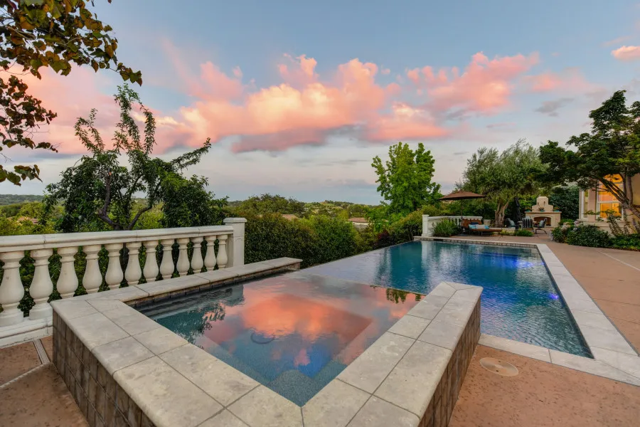 Casa moderna com piscina de borda infinita, evocando a ideia de uma casa de férias, ideal para ilustrar o conceito de segundo crédito habitação para comprar uma nova propriedade.