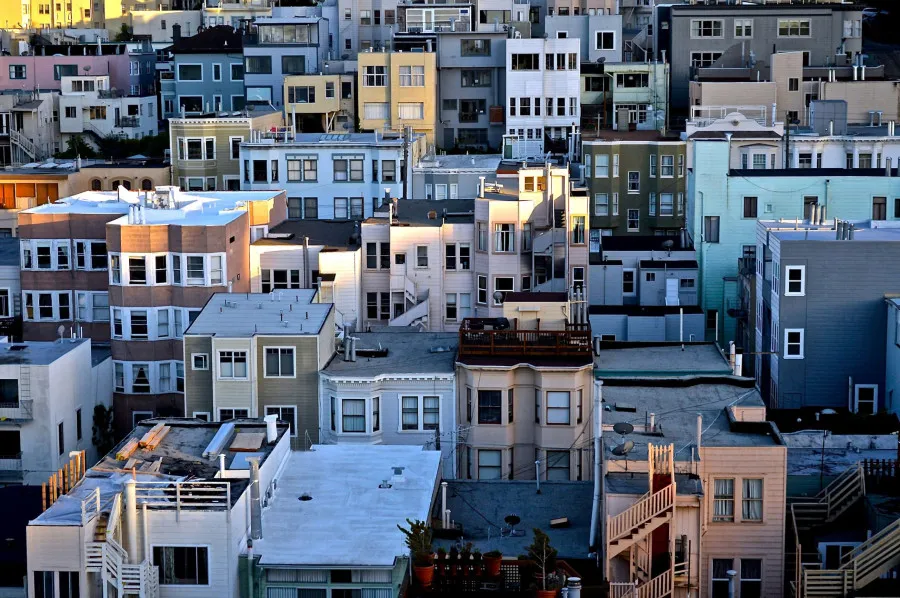 Vista de prédios residenciais coloridos e sobrepostos numa área urbana.